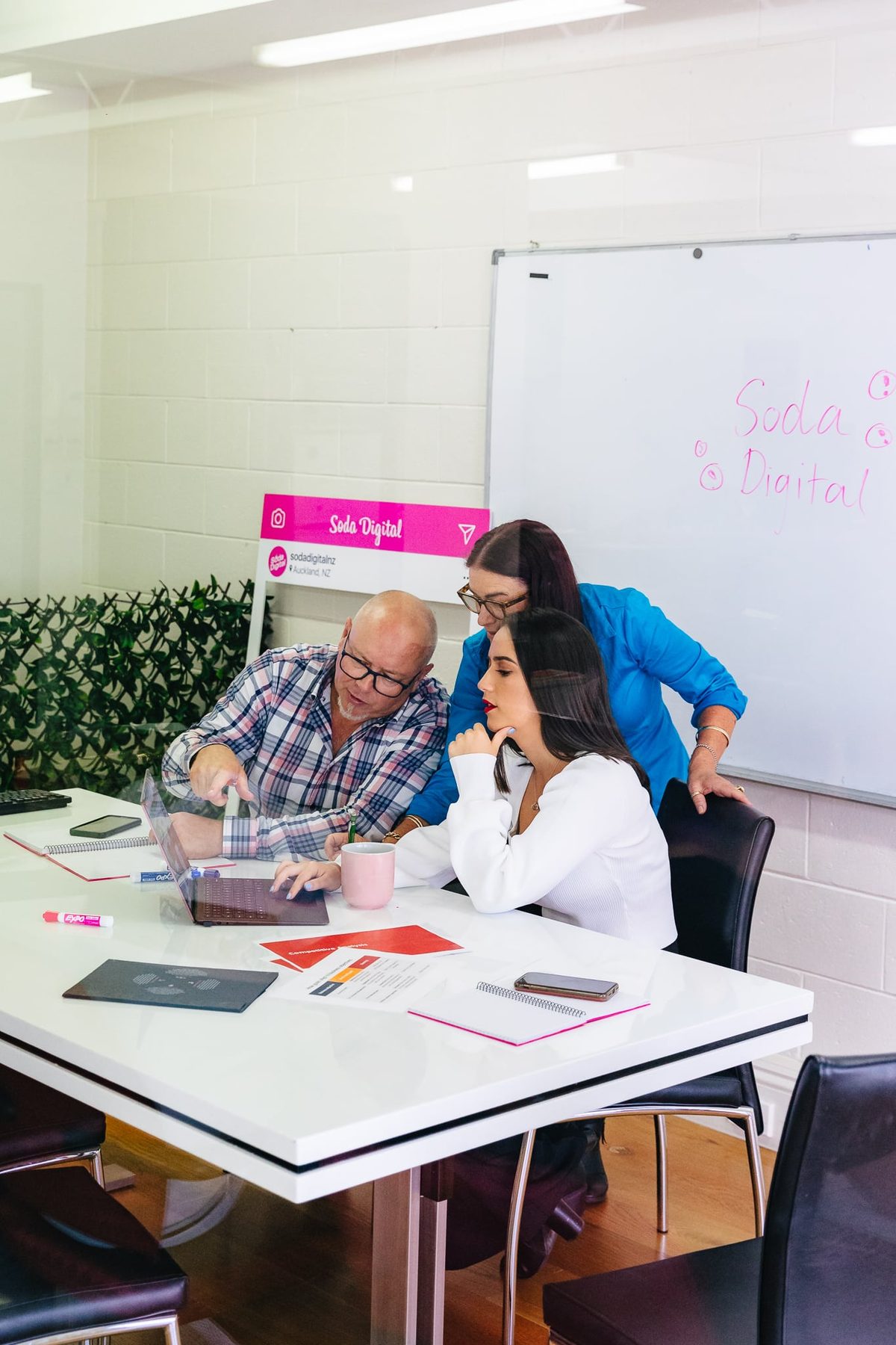 Team photo of digital marketing agency members on a laptop