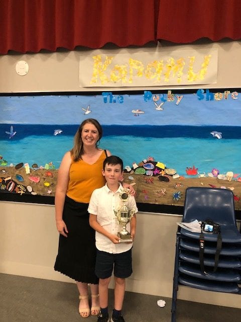 Amanda Hoffman posing with her son who just won a trophy